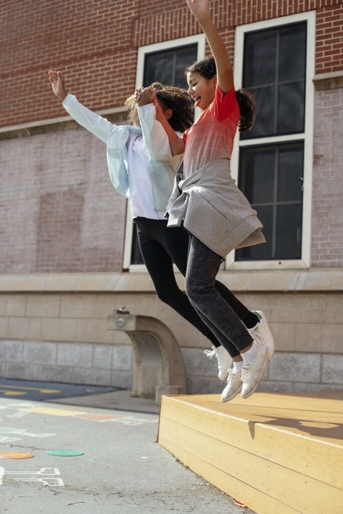 Happy girls jumping on ground